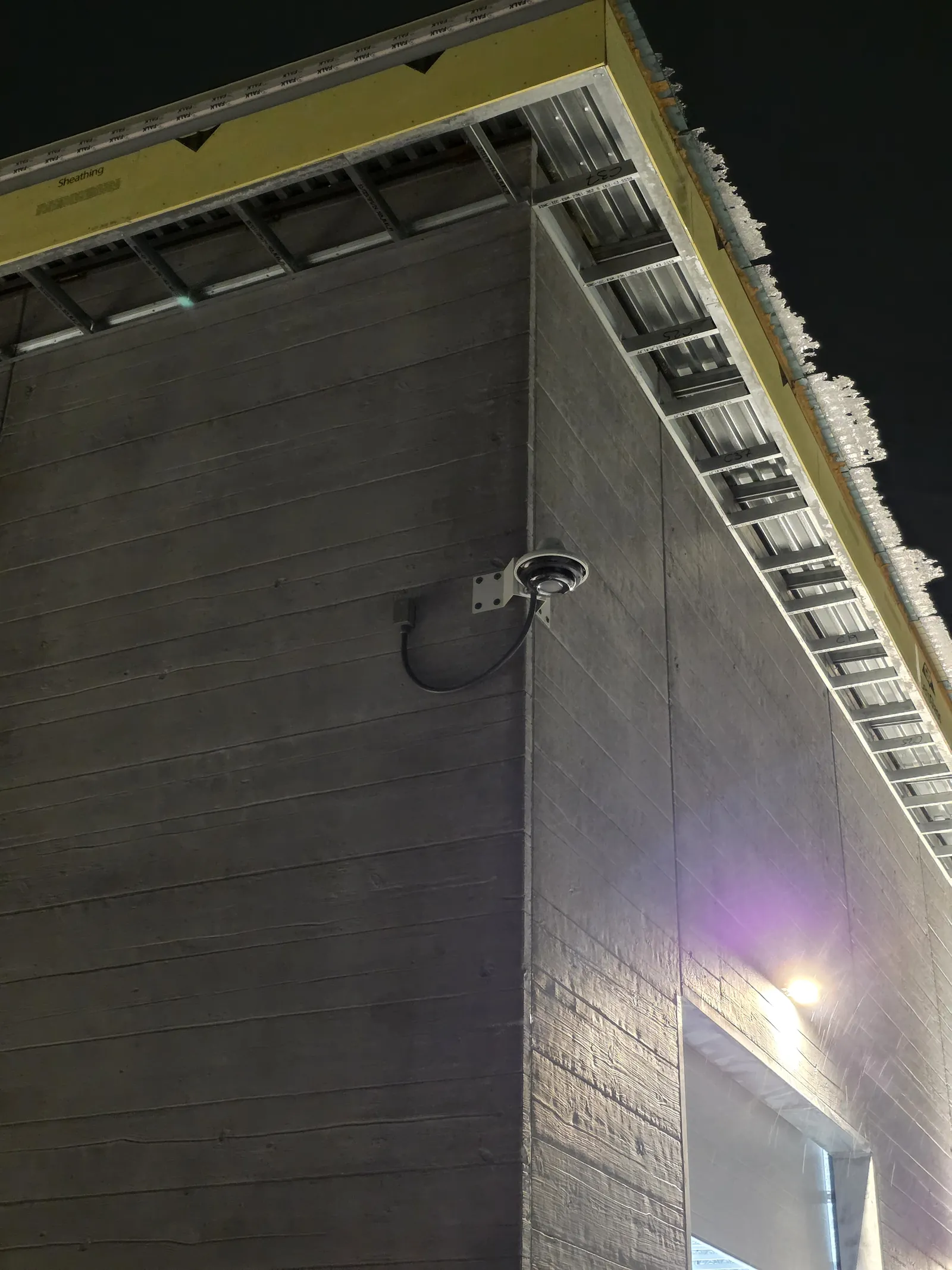 Exterior security camera mounted on a commercial building corner by INTEK